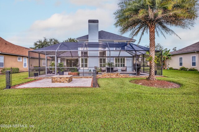 rear view of property featuring a lanai, a yard, and a patio