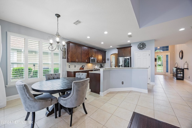 tiled dining area with a chandelier