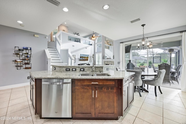 kitchen with a textured ceiling, a kitchen island with sink, sink, pendant lighting, and dishwasher