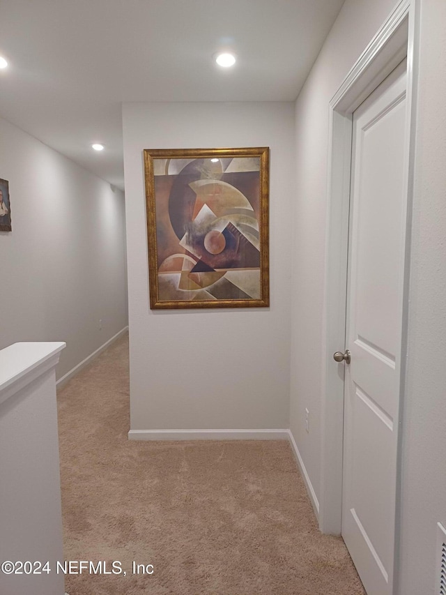 hallway featuring light colored carpet