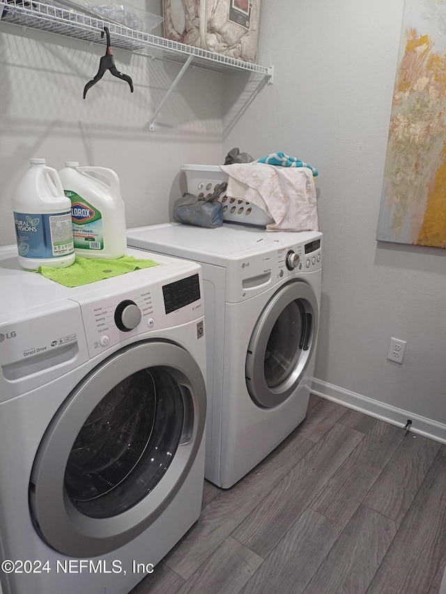 laundry area featuring washing machine and dryer and dark hardwood / wood-style floors