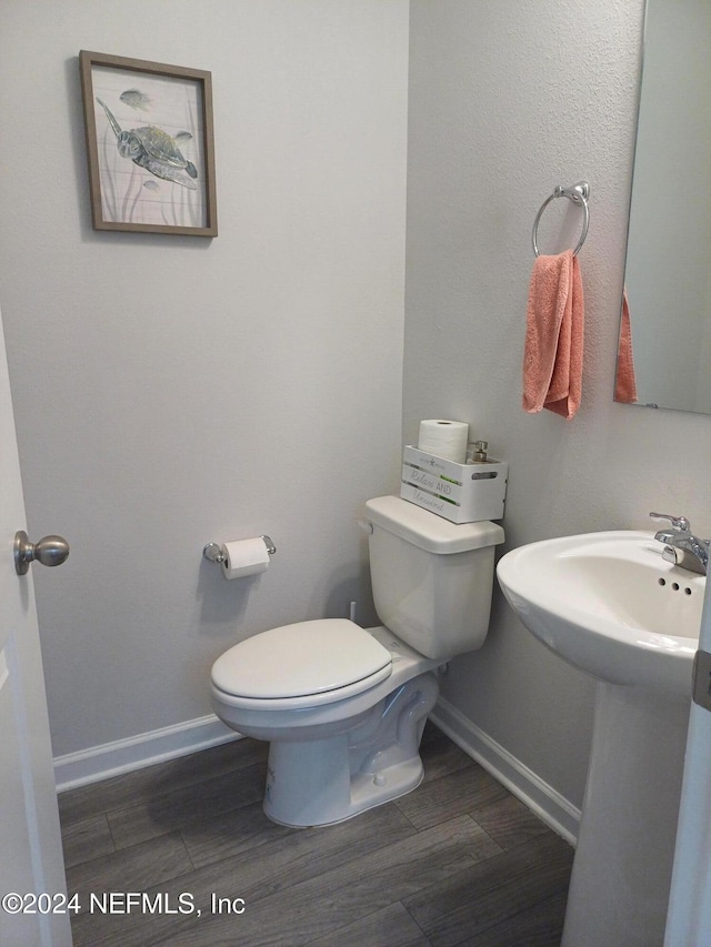 bathroom featuring hardwood / wood-style floors and toilet