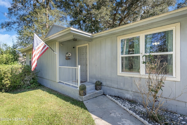 entrance to property featuring a lawn