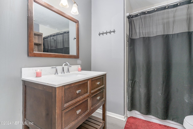 bathroom with hardwood / wood-style flooring, vanity, a shower with shower curtain, and toilet