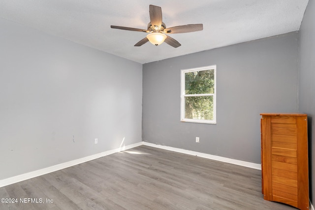 spare room featuring hardwood / wood-style flooring, ceiling fan, and a textured ceiling