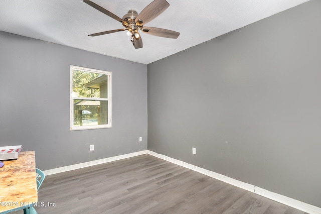 empty room featuring a textured ceiling, ceiling fan, and dark hardwood / wood-style floors