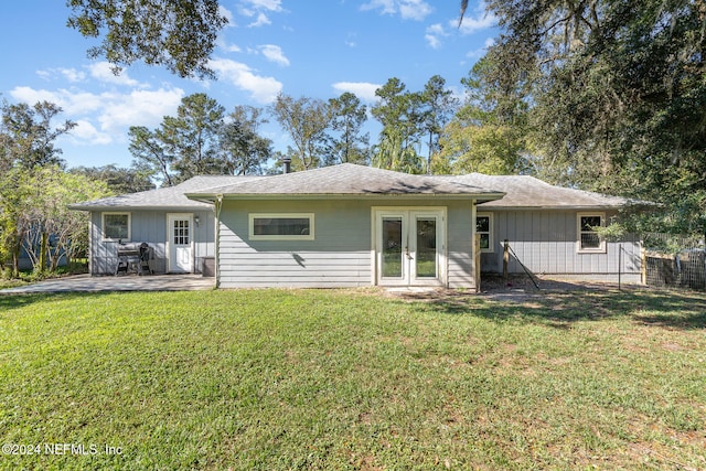 rear view of house featuring french doors, a patio, and a lawn