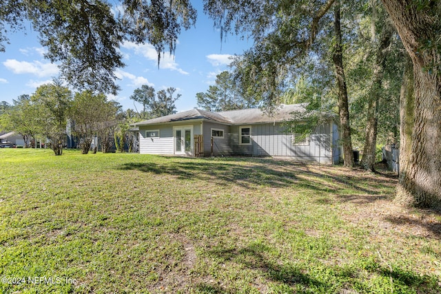 back of property with french doors and a yard