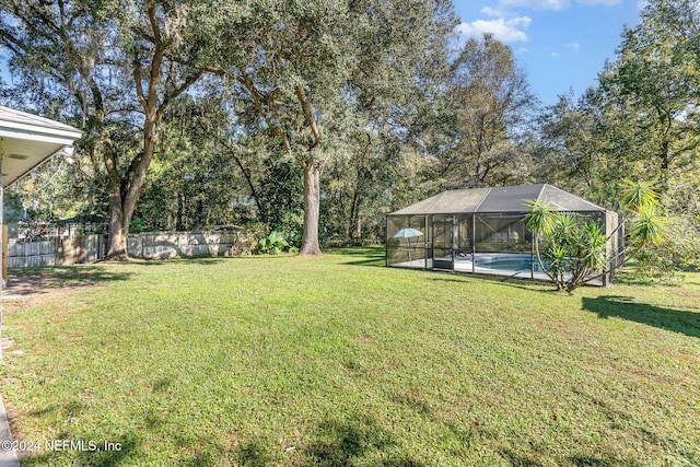 view of yard featuring a fenced in pool and a lanai