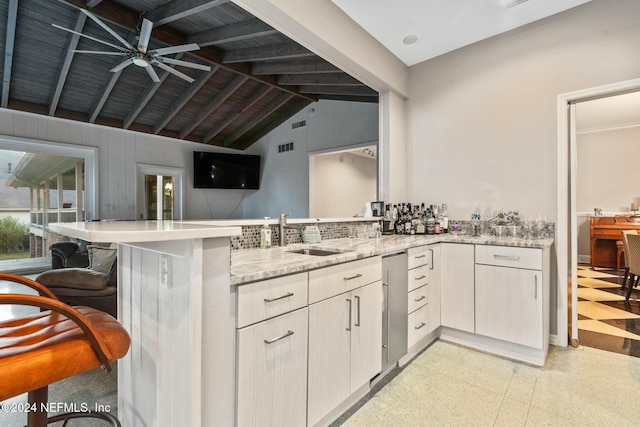 1124 Oriental Gardens Rd, Jacksonville, FL 32207 - kitchen featuring a peninsula, light stone counters, ceiling fan, light floors, and a kitchen bar