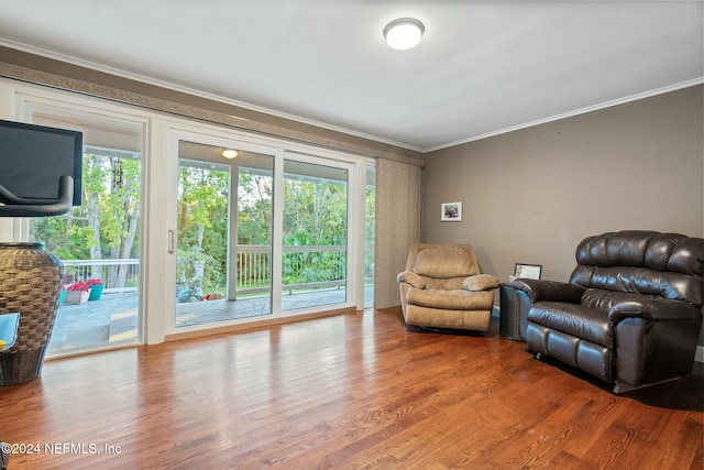 sitting room with crown molding, a healthy amount of sunlight, and hardwood / wood-style flooring