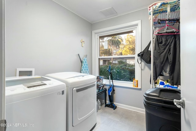 laundry room with separate washer and dryer and crown molding