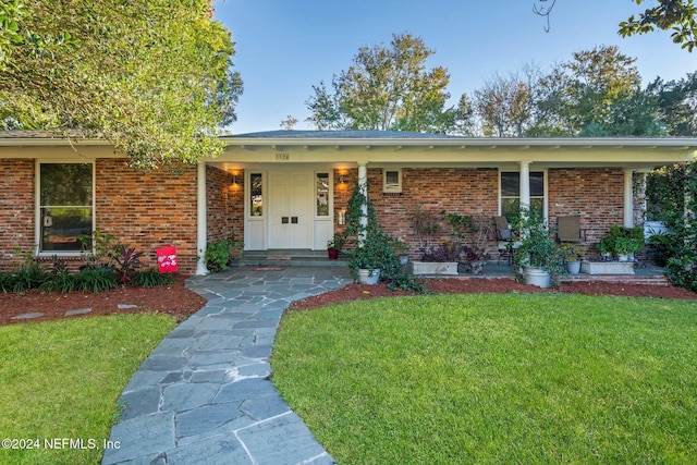 ranch-style house with a front lawn and a porch