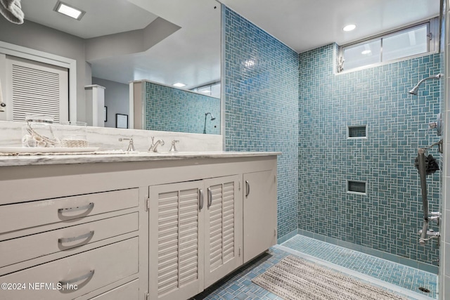 bathroom featuring tiled shower and vanity