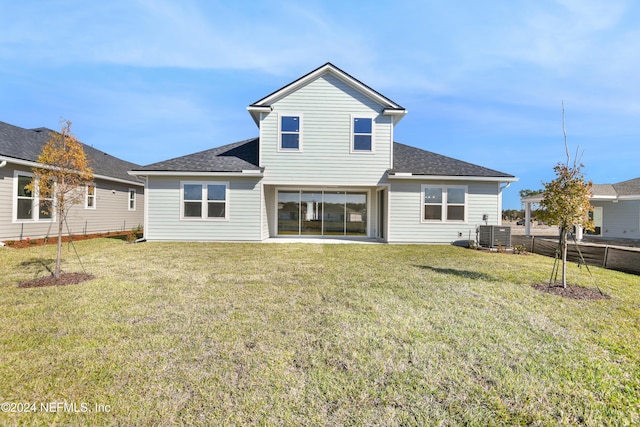 back of property with a lawn and central AC unit