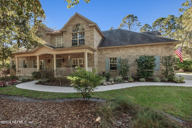 view of front facade with covered porch and a front lawn