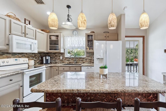 kitchen with pendant lighting, white appliances, a breakfast bar area, and sink