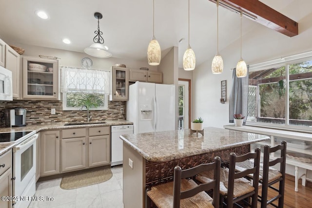 kitchen featuring light stone counters, sink, hanging light fixtures, and white appliances