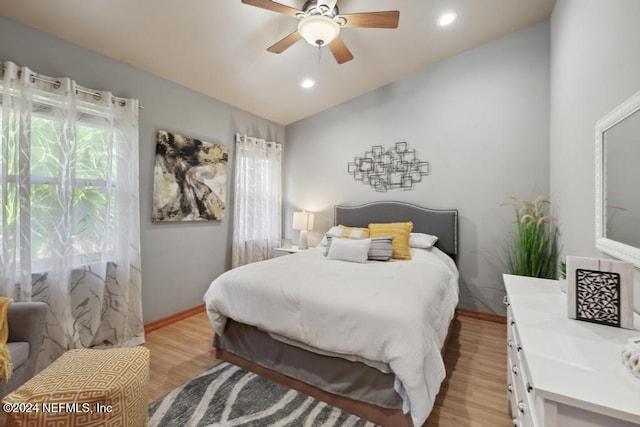 bedroom with ceiling fan, lofted ceiling, and light wood-type flooring