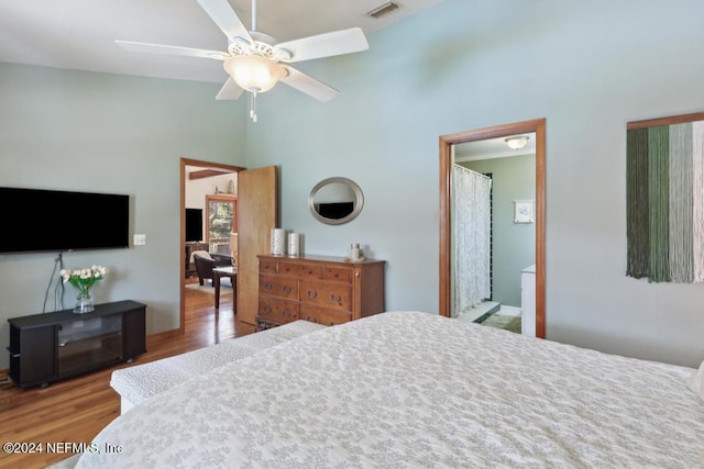 bedroom featuring ensuite bath, ceiling fan, and hardwood / wood-style flooring