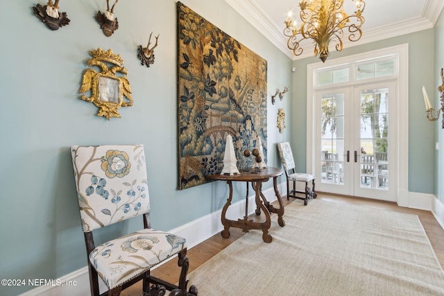 sitting room with hardwood / wood-style floors, an inviting chandelier, french doors, and ornamental molding