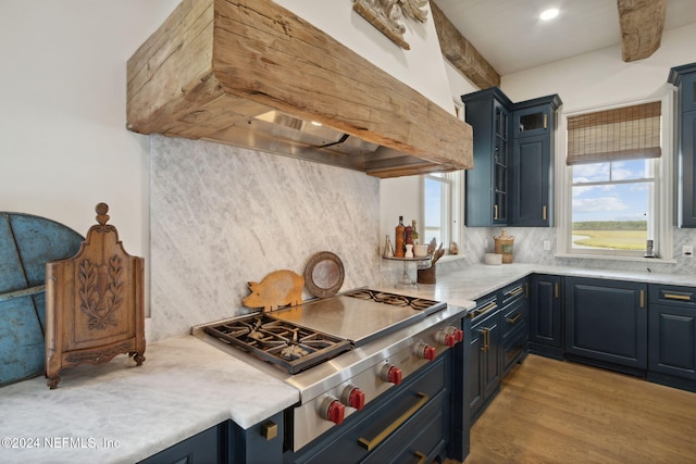 kitchen with stainless steel gas cooktop, beamed ceiling, backsplash, custom exhaust hood, and hardwood / wood-style flooring