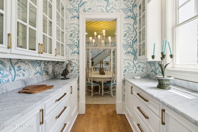 bar featuring white cabinetry, dark hardwood / wood-style flooring, and light stone counters