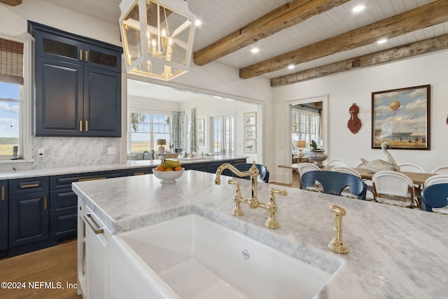 kitchen featuring backsplash, sink, dark hardwood / wood-style floors, decorative light fixtures, and beam ceiling