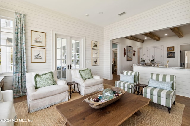 living room with beam ceiling, wood-type flooring, and french doors