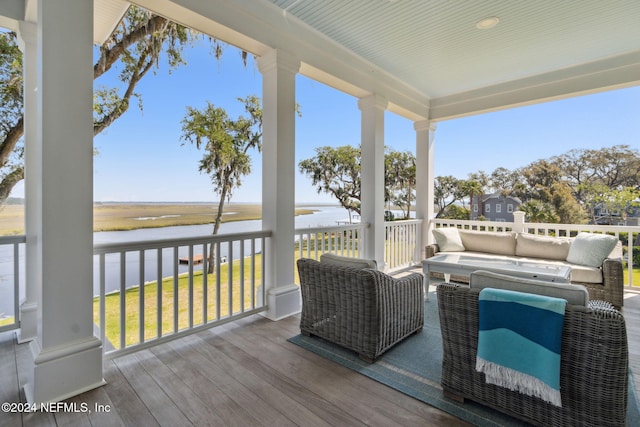 deck with outdoor lounge area and a water view