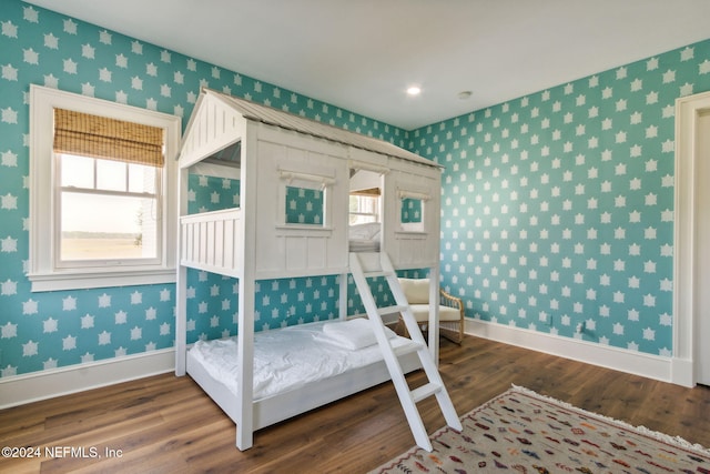 bedroom with multiple windows and hardwood / wood-style floors