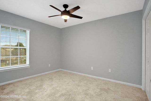 spare room featuring ceiling fan and light carpet