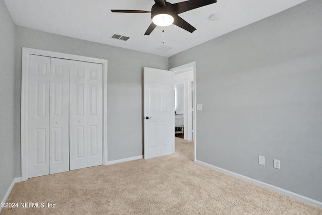 unfurnished bedroom featuring light colored carpet, a closet, and ceiling fan