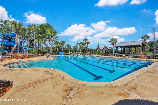 view of pool featuring a gazebo, a water slide, and a patio