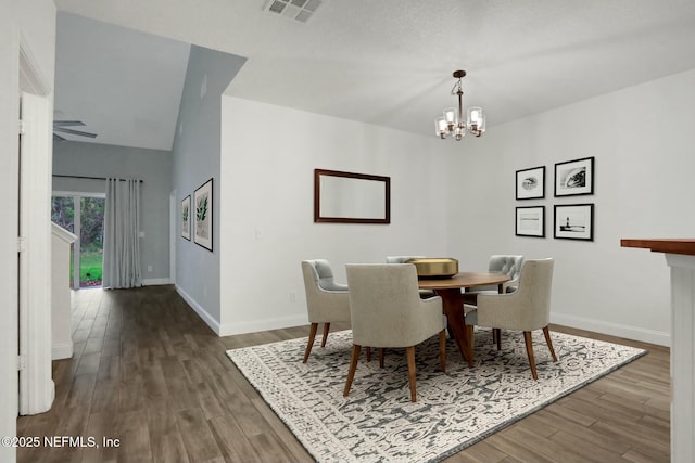 dining room featuring dark hardwood / wood-style flooring, a notable chandelier, and lofted ceiling