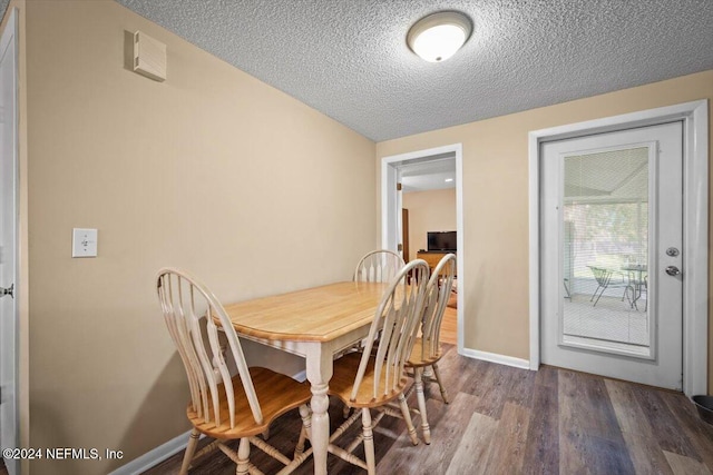 dining area with wood-type flooring and a textured ceiling