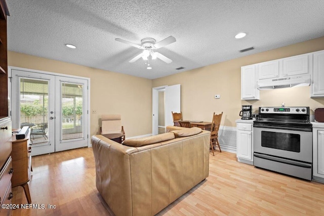 living room featuring ceiling fan, french doors, light hardwood / wood-style floors, and a textured ceiling