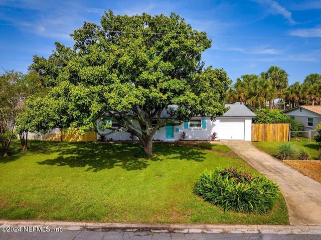 obstructed view of property featuring a garage and a front lawn