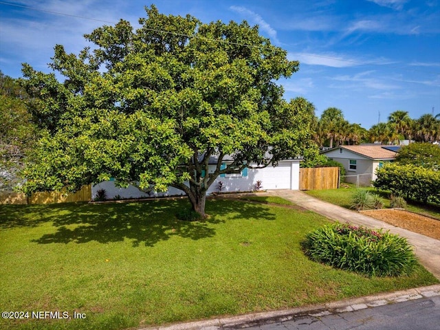 view of property hidden behind natural elements featuring a front yard