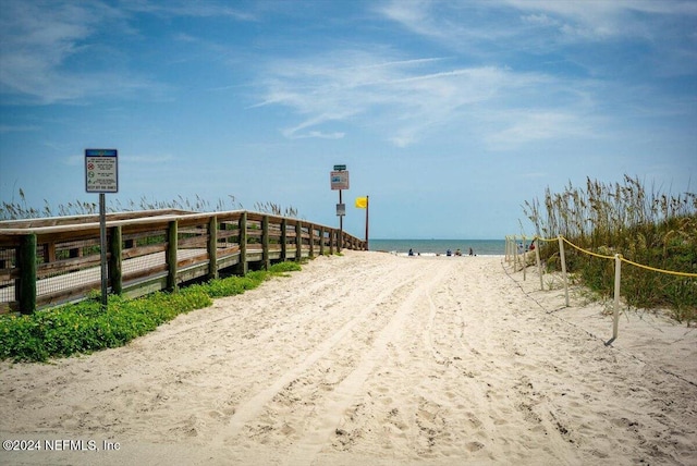 surrounding community with a water view and a beach view