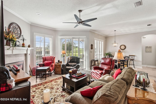 living room featuring light wood-type flooring, a textured ceiling, and ornamental molding