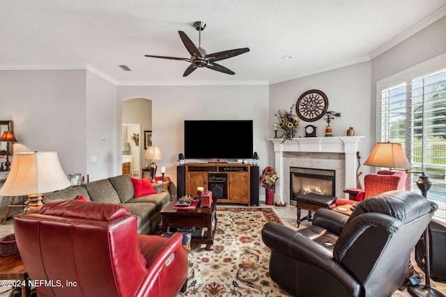 living room with a textured ceiling, ceiling fan, and ornamental molding