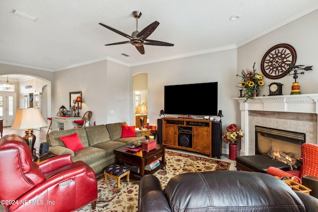 living room featuring crown molding, a fireplace, and ceiling fan