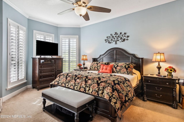 carpeted bedroom featuring ceiling fan and crown molding