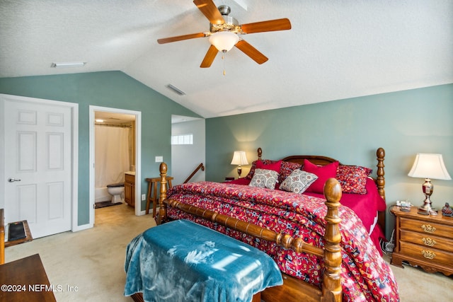 carpeted bedroom with a textured ceiling, connected bathroom, ceiling fan, and lofted ceiling