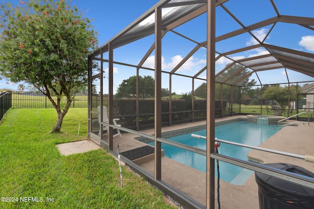 view of pool featuring glass enclosure, a patio area, a yard, and an in ground hot tub