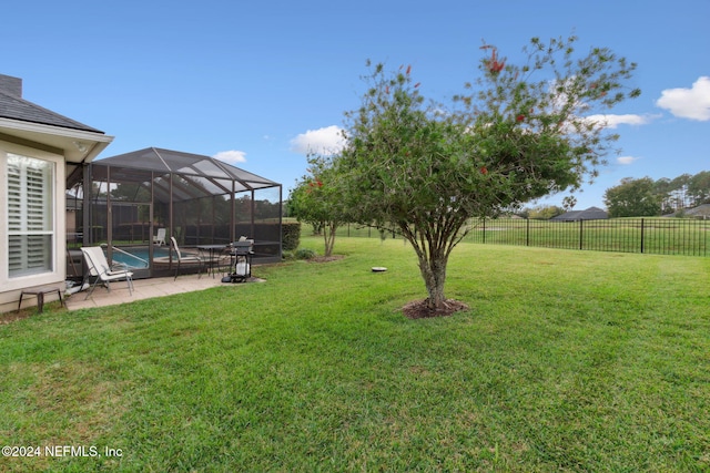 view of yard with a fenced in pool, glass enclosure, and a patio area