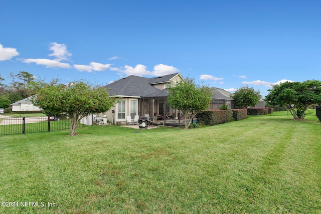 back of property with a patio, glass enclosure, and a lawn