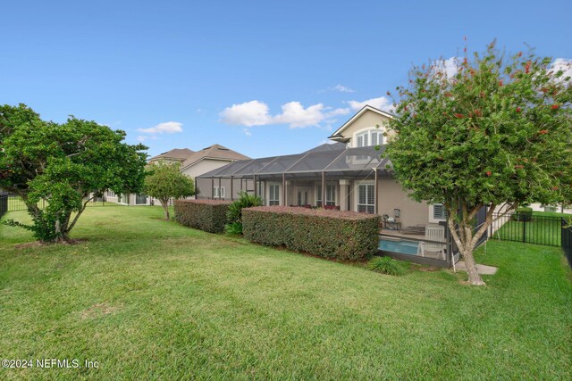 view of yard featuring a fenced in pool and glass enclosure