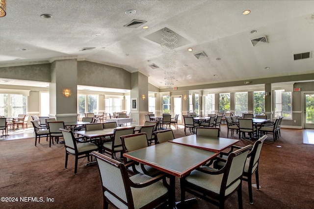 carpeted dining space with a textured ceiling, plenty of natural light, vaulted ceiling, and a notable chandelier